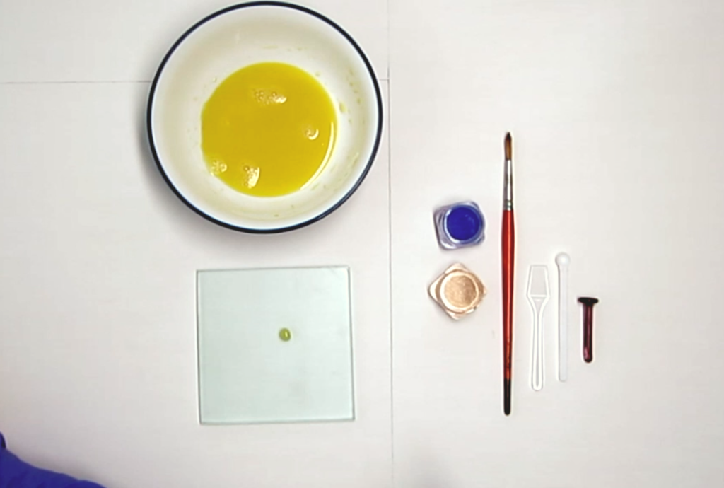 Supplies for pigment mixing. Egg mixture, pigments, glass plate, brush, spatula, spoon, muller